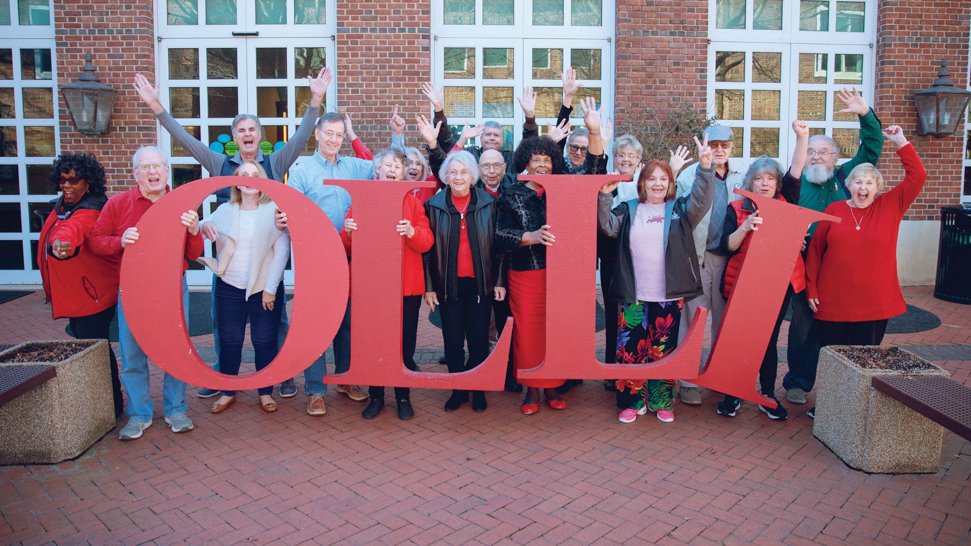 Group holding letters that spell OLLI